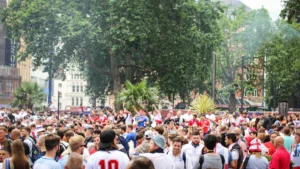A massive crowd of football fans gathered in a city square to celebrate.