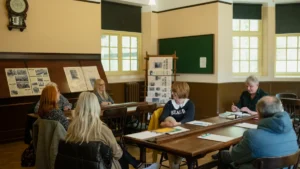 A group of adult learners sitting around large wooden tables in a traditional wood-paneled classroom in Buckinghamshire.