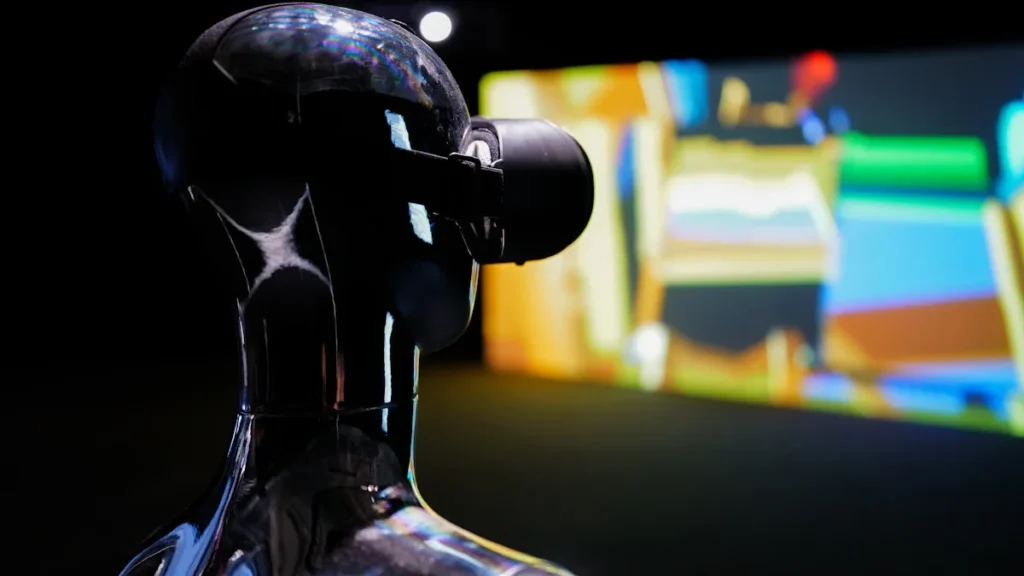 A sleek robot-like mannequin wearing a virtual reality headset against a dark background.