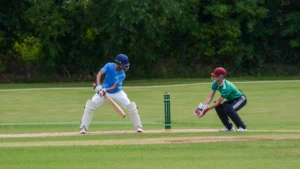 A young batsman and wicketkeeper during a school cricket match in Birmingham.