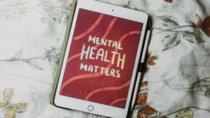 A tablet displaying the words 'Mental Health Matters' against a patterned floral background.