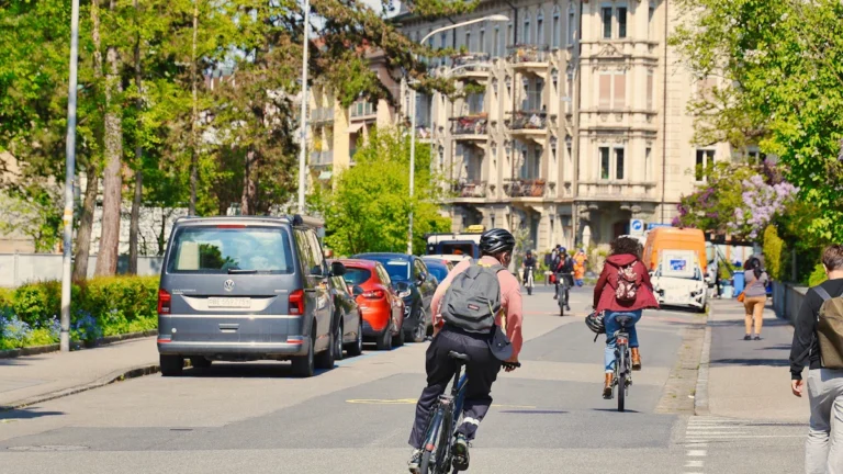 A vibrant urban street featuring cyclists and pedestrians using integrated transport links in a safe, modern environment.