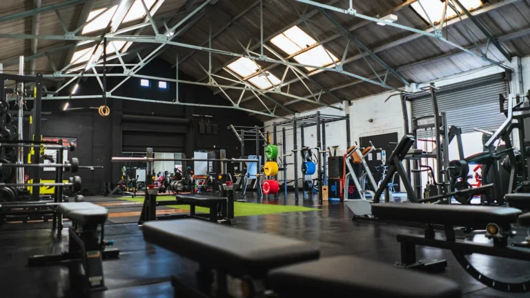 A wide view of the interior of the new Addiscombe fitness hub in Croydon, featuring weightlifting racks and benches in an industrial-style gym.
