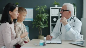 A professional pediatrician discusses wellness and health strategies with a mother and young child in a clinical setting.