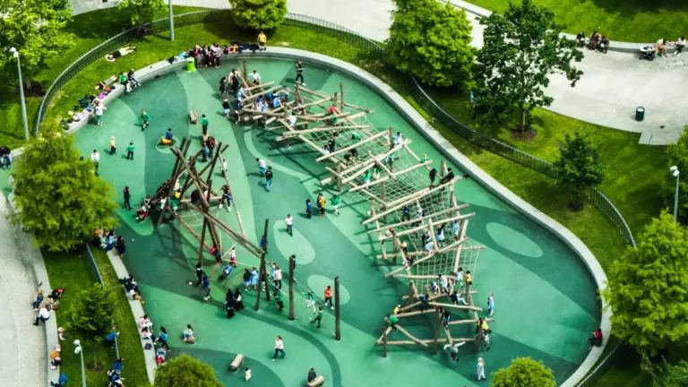 Aerial view of a vibrant public park with children using a climbing structure.