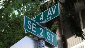 Two green street signs at an urban intersection, symbolizing the process of renaming city streets.