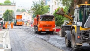 Construction vehicles and heavy machinery resurfacing a city road as part of a major repair project.