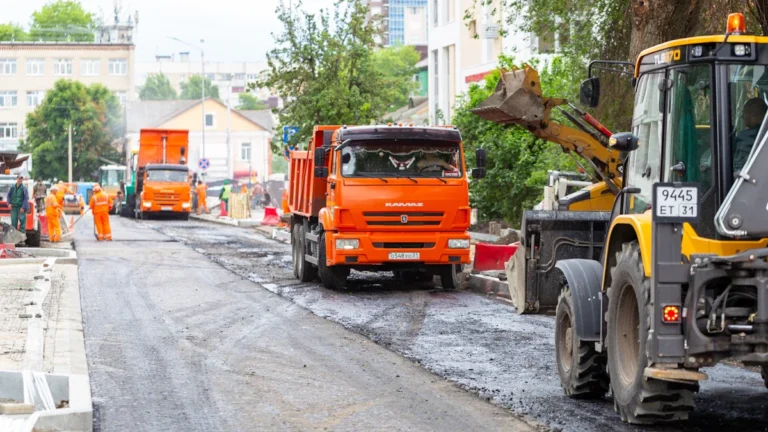 Construction vehicles and heavy machinery resurfacing a city road as part of a major repair project.