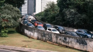 A long queue of cars stuck in heavy traffic on a raised flyover ramp.