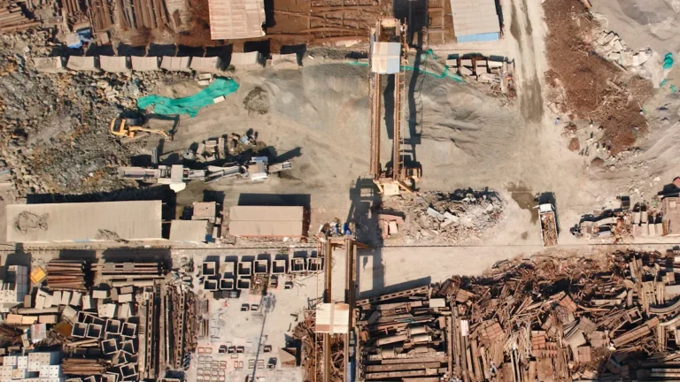 Aerial view of an extensive scrap metal yard showing various piles of industrial waste and recycling.