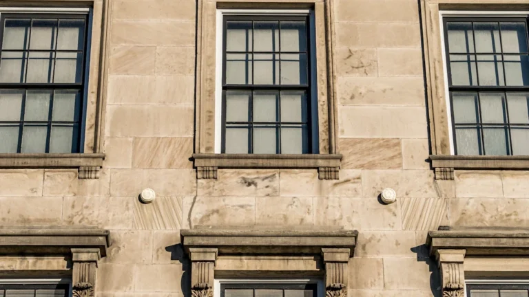 A close-up of the architectural stonework and sash windows of a traditional civic building.