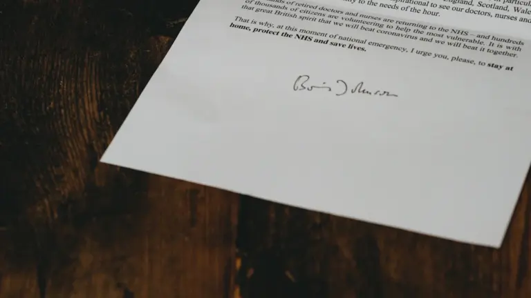 Government letter with official signature resting on a dark wooden table.