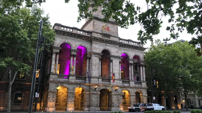 A grand, illuminated municipal building representing the seat of local government power.