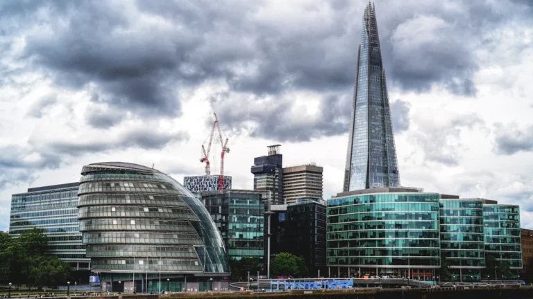 A view of the London skyline featuring the Shard and glass buildings along the River Thames.