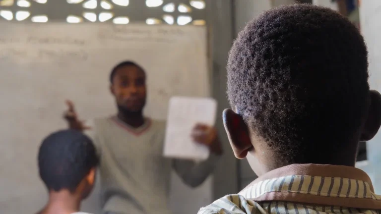 A teacher stands in front of a classroom instructing students during a school lesson.