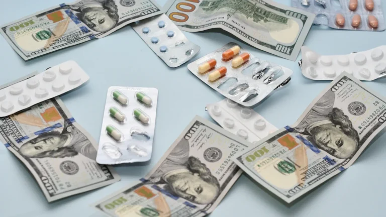 Blister packs of medication resting on a spread of twenty-euro banknotes.