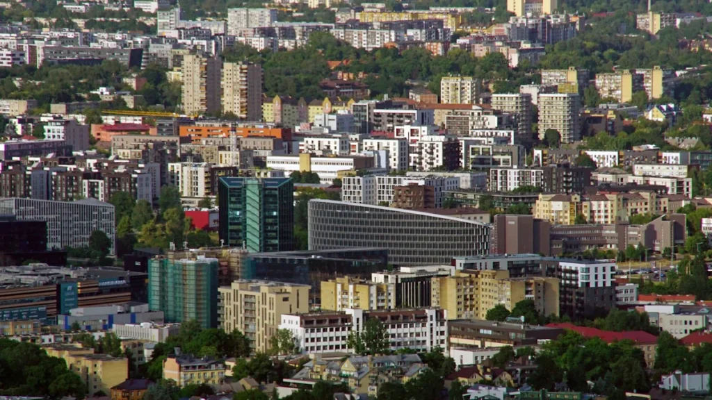 A high-angle panoramic view of residential and commercial buildings across the city of Vilnius, Lithuania.