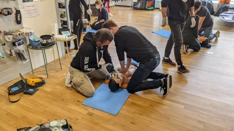 A group of citizens practicing CPR on training mannequins during a first aid workshop.