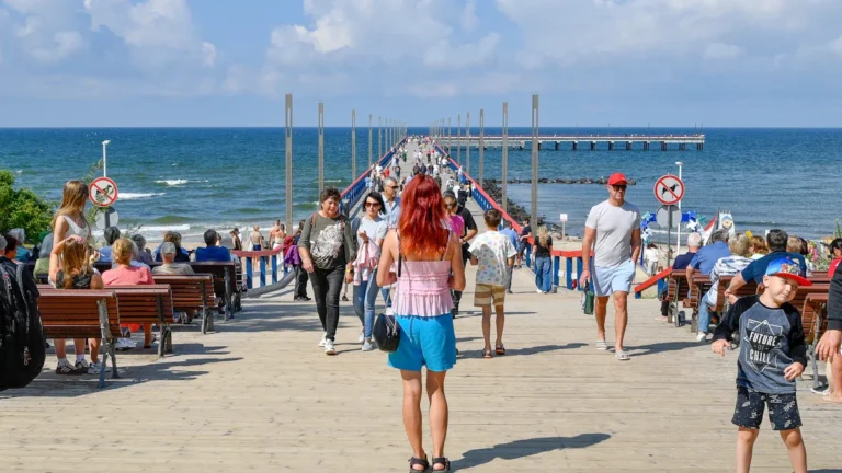 Families and children walking along the iconic Palanga Pier in Lithuania, representing the nation's focus on family well-being.