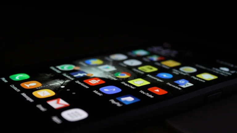 A smartphone screen illuminated in a dark setting, showing various application icons including Gmail and messaging.