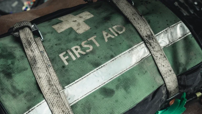 Close-up of a professional green and black first aid kit bag with reflective strips.