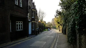 A quiet residential street in Liverpool featuring traditional brick terraced houses and lush green ivy.