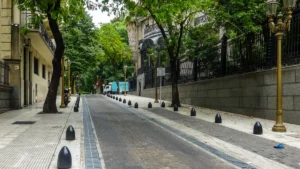 A tranquil, empty street with lush green trees and classic architecture, representing the peace restored to the neighborhood.