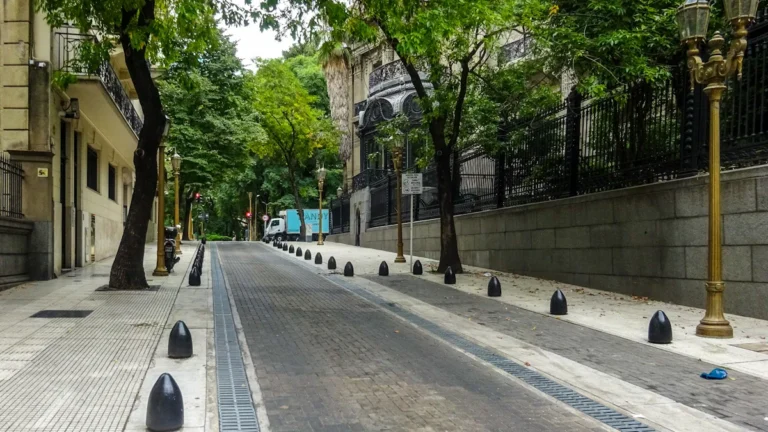 A tranquil, empty street with lush green trees and classic architecture, representing the peace restored to the neighborhood.