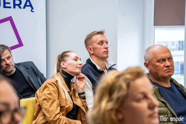 Attentive audience members sitting and listening intently during a community presentation in an indoor setting.