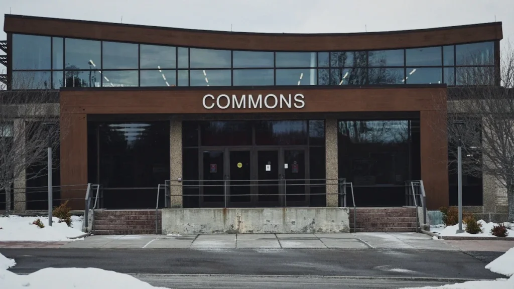 A modern building with a large 'COMMONS' sign, representing a new community family support hub.