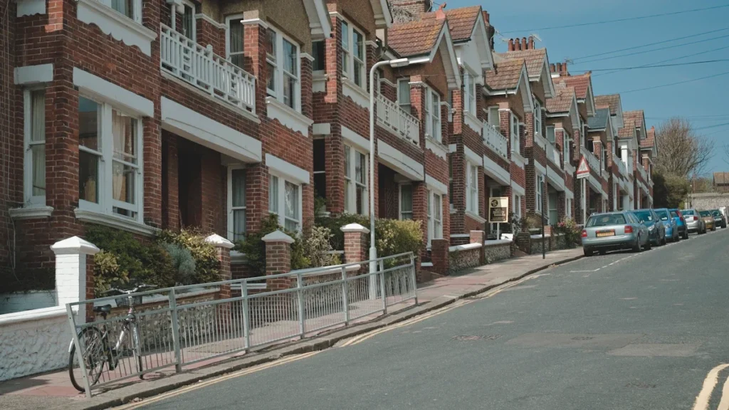 A row of red brick terraced houses on a typical residential street.