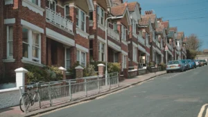 A row of red brick terraced houses on a typical residential street.