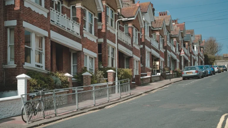 A row of red brick terraced houses on a typical residential street.