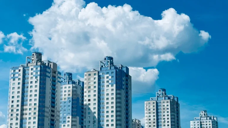 Modern multi-story apartment buildings in Panevėžys under a bright blue sky.