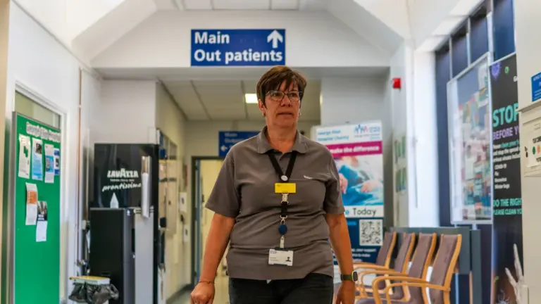 A volunteer walking through a hospital corridor in the United Kingdom.