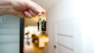 A person holding a set of house keys with a house-shaped keychain, symbolizing new legal rights for residents.