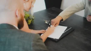 A couple signs a rental agreement in Shropshire as a third party points to the document.