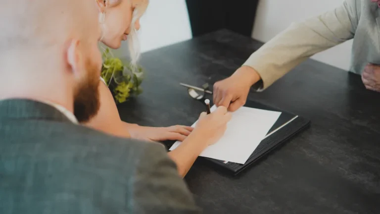 A couple signs a rental agreement in Shropshire as a third party points to the document.