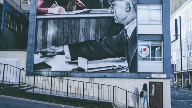 A large-scale mural on a multi-story building at the corner of North Portland Street and George Street in Glasgow.