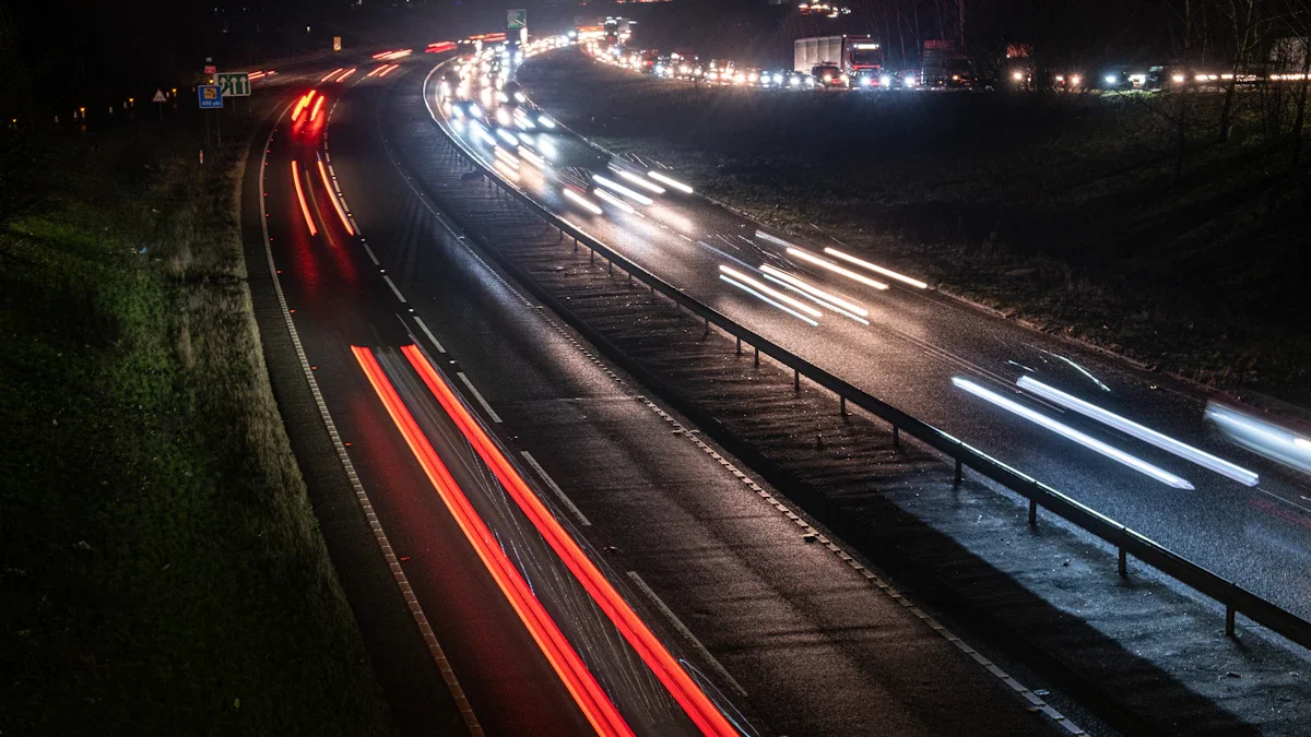 Time-lapse photography showing bright red and white traffic light trails on a busy UK dual carriageway at night.