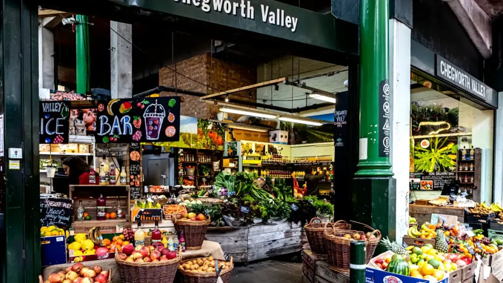 Colorful fruit and vegetable stall at a bustling London market in the UK.