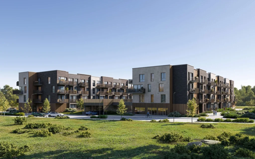 Modern multi-story apartment buildings with dark facades and balconies overlooking a grassy field.