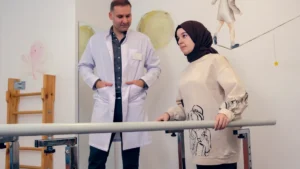 A healthcare professional assists a patient in a physical therapy room featuring vibrant wall murals.