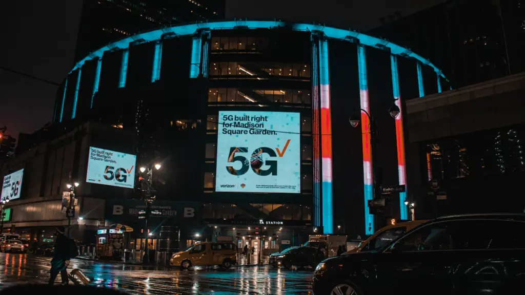 Madison Square Garden arena exterior at night illuminated by bright 5G signage.