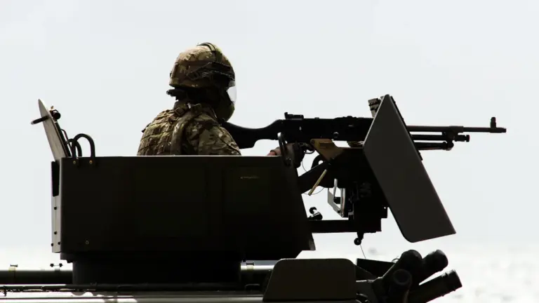 British soldier manning a heavy machine gun on a military tank in London.