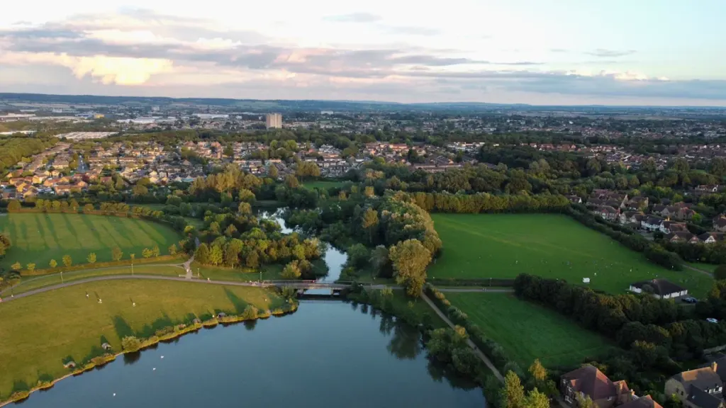 Aerial view of Furzton Lake and residential growth in Milton Keynes at sunset.