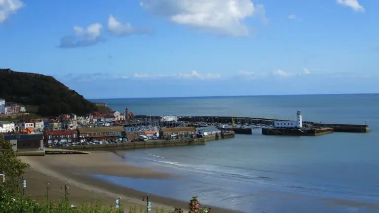 Panoramic view of Scarborough harbour, West Pier, and the coastal headland in England.