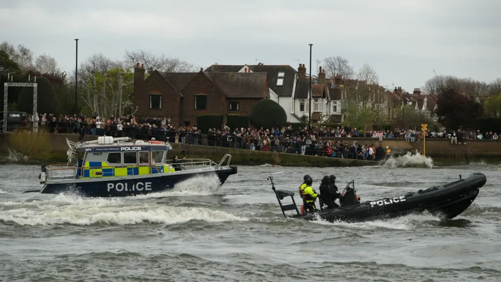 Metropolitan police patrol boats speeding along the River Thames in London.