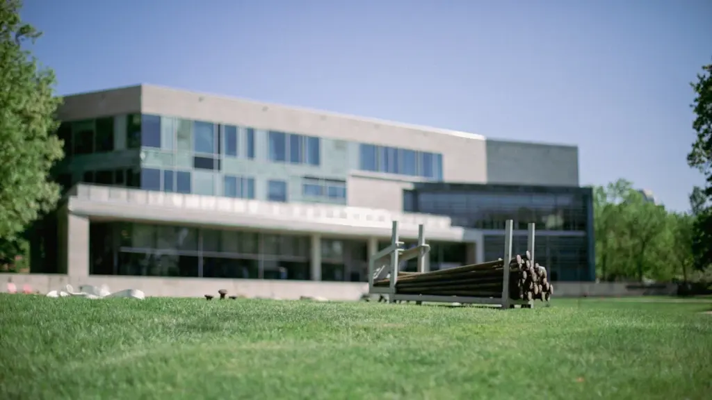 Modern educational building with green lawn and construction materials on a sunny day.